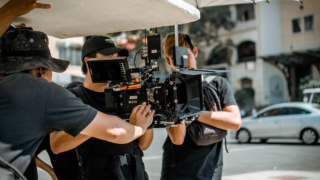 People working for a marketing video production using a RED camera system in a sunny day.